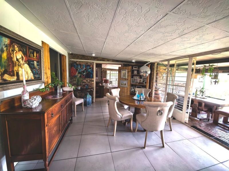 Spacious dining area featuring tiled flooring, exposed brick walls, and large sliding glass doors that provide natural light and access to the patio.
