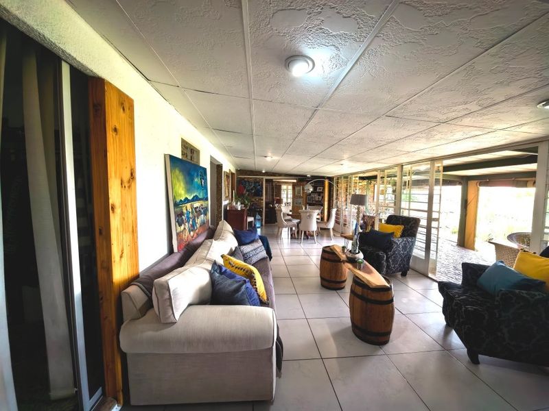 Spacious open-plan living and dining area featuring large sliding glass doors, tiled flooring, and a textured ceiling.