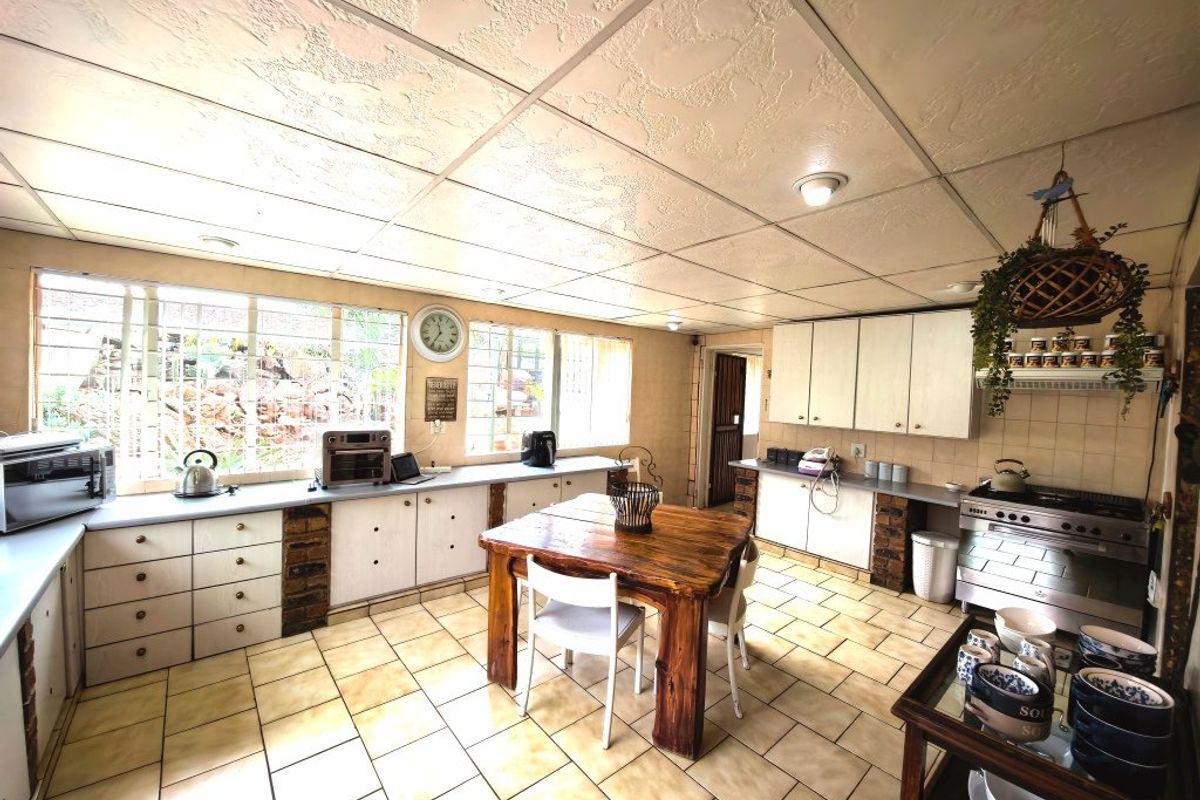 Spacious kitchen featuring tiled flooring, extensive built-in cabinetry, and a gas stove, offering a functional layout with potential for modern updates.