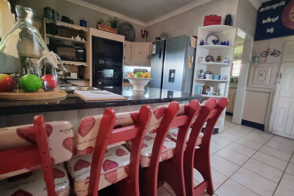 A functional kitchen featuring granite countertops, built-in oven, and tiled flooring, offering a practical layout for daily meal preparation.
