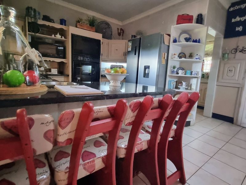A functional kitchen featuring granite countertops, built-in oven, and tiled flooring, offering a practical layout for daily meal preparation.