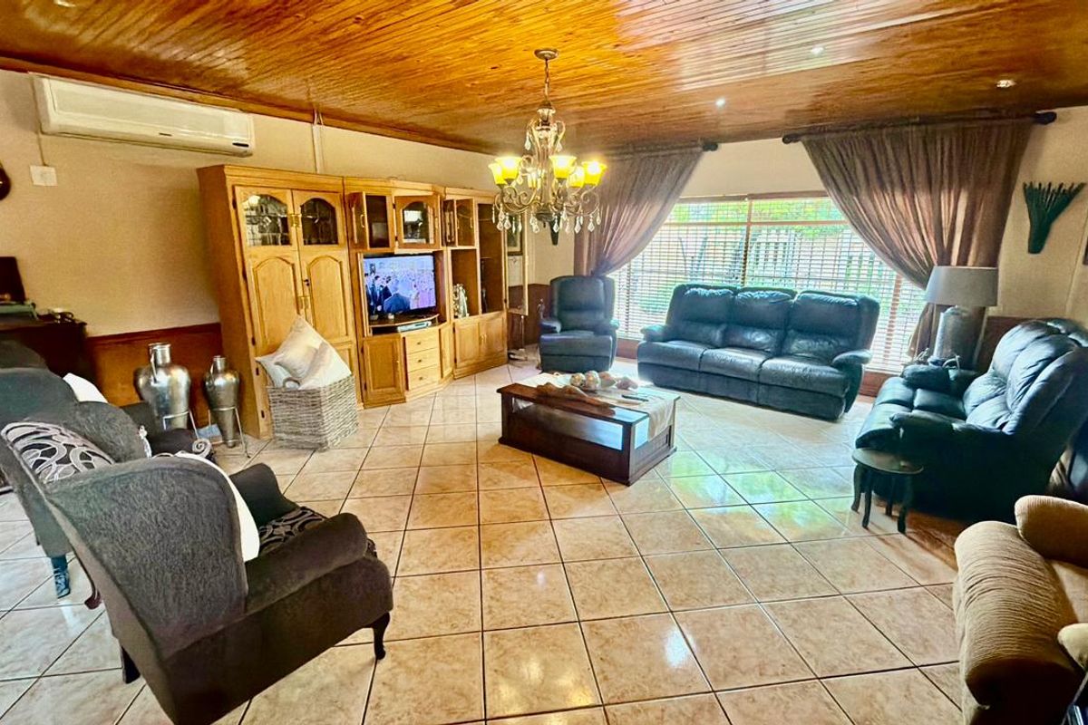 Spacious living room featuring ceramic floor tiles, a timber tongue and groove ceiling, and a wall-mounted split system air conditioner.