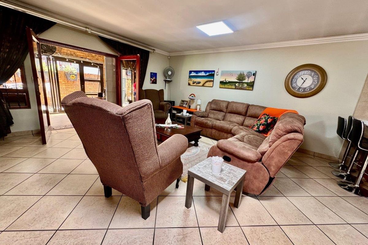A spacious living area featuring tiled flooring and a sliding glass door providing direct access to the outdoor patio space.