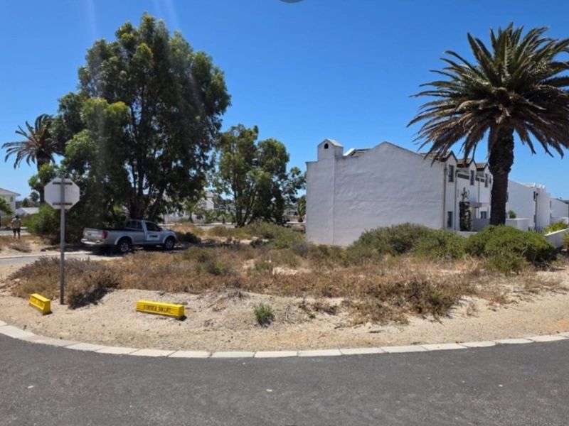 A street-level view of the property approach, showing the paved road, verge, and surrounding residential landscape.