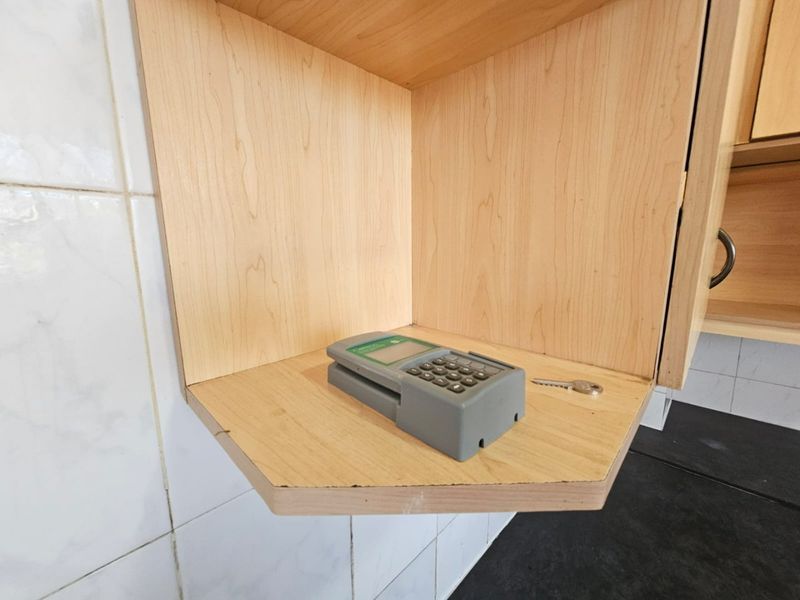 A close-up view of built-in wooden kitchen cabinetry with tiled splashback detailing.