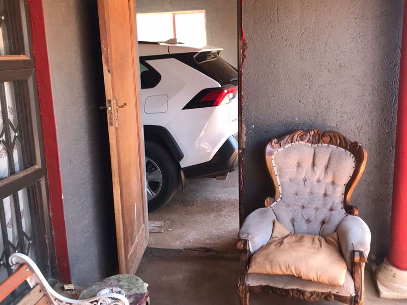 A covered patio area featuring painted masonry walls and direct access to a garage space.