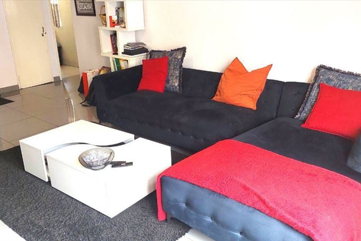 A living room area featuring tiled flooring and neutral wall finishes, providing a functional space for relaxation.