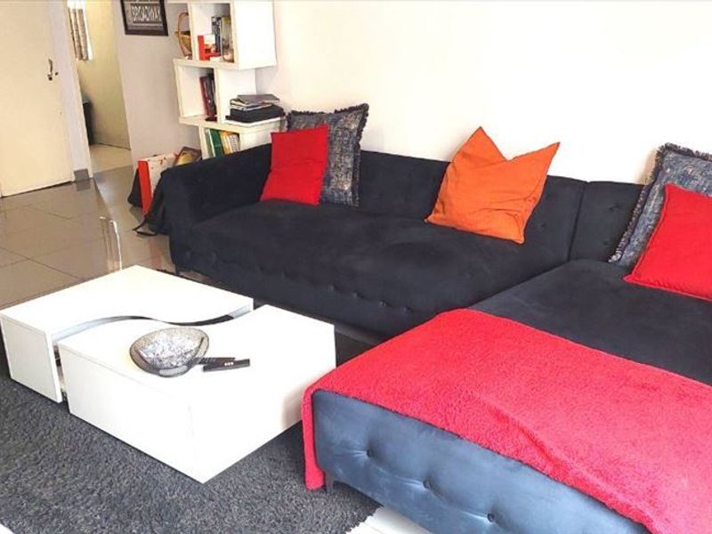A living room area featuring tiled flooring and neutral wall finishes, providing a functional space for relaxation.