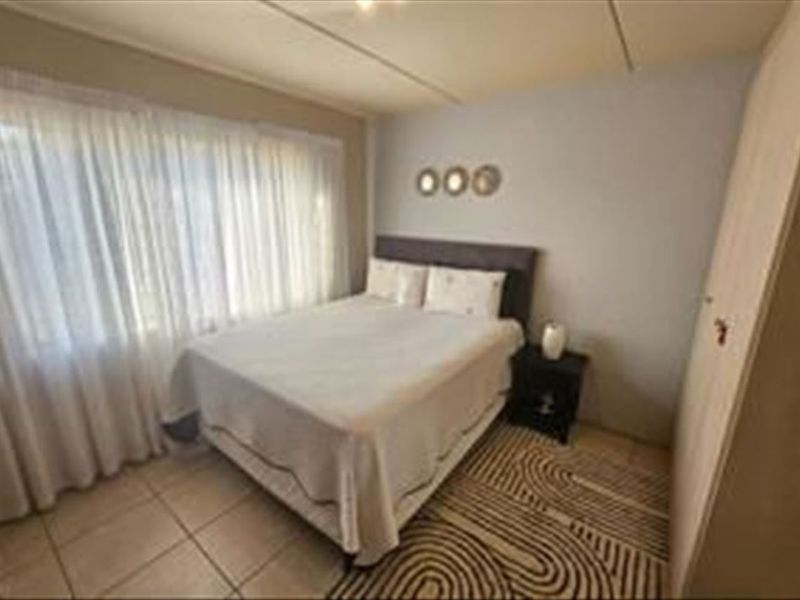 A functional bedroom featuring tiled flooring and a built-in wardrobe, offering a neutral space ready for personalization.