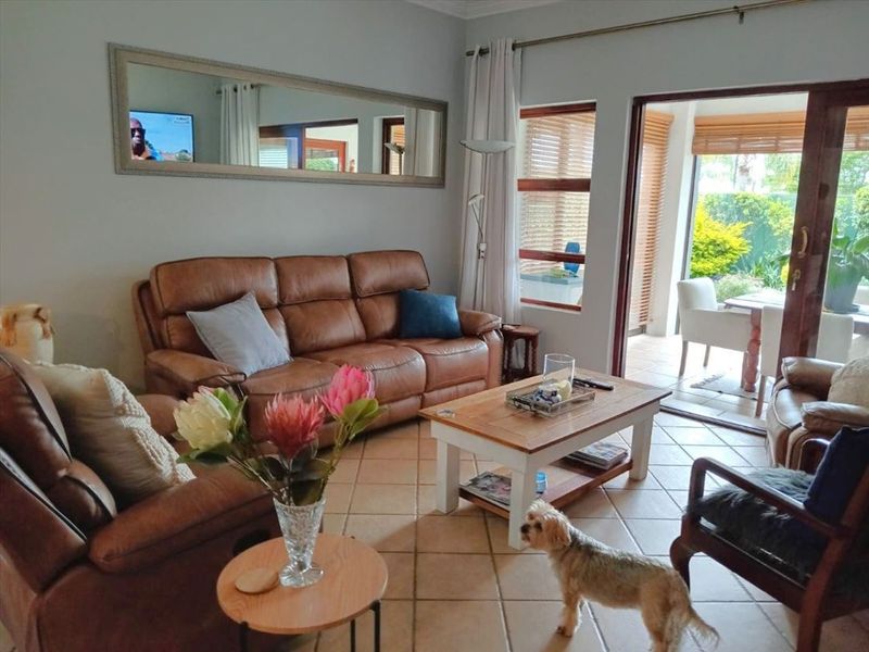 A comfortable living room featuring tiled flooring and a large sliding glass door that provides direct access to the outdoor patio area.
