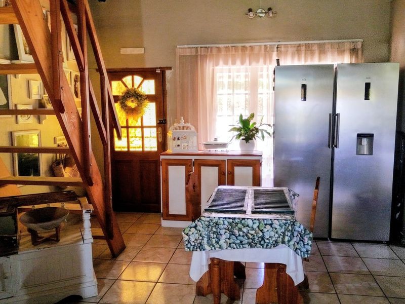 Entrance area featuring a wooden staircase, tiled flooring, and a timber front door with natural light.
