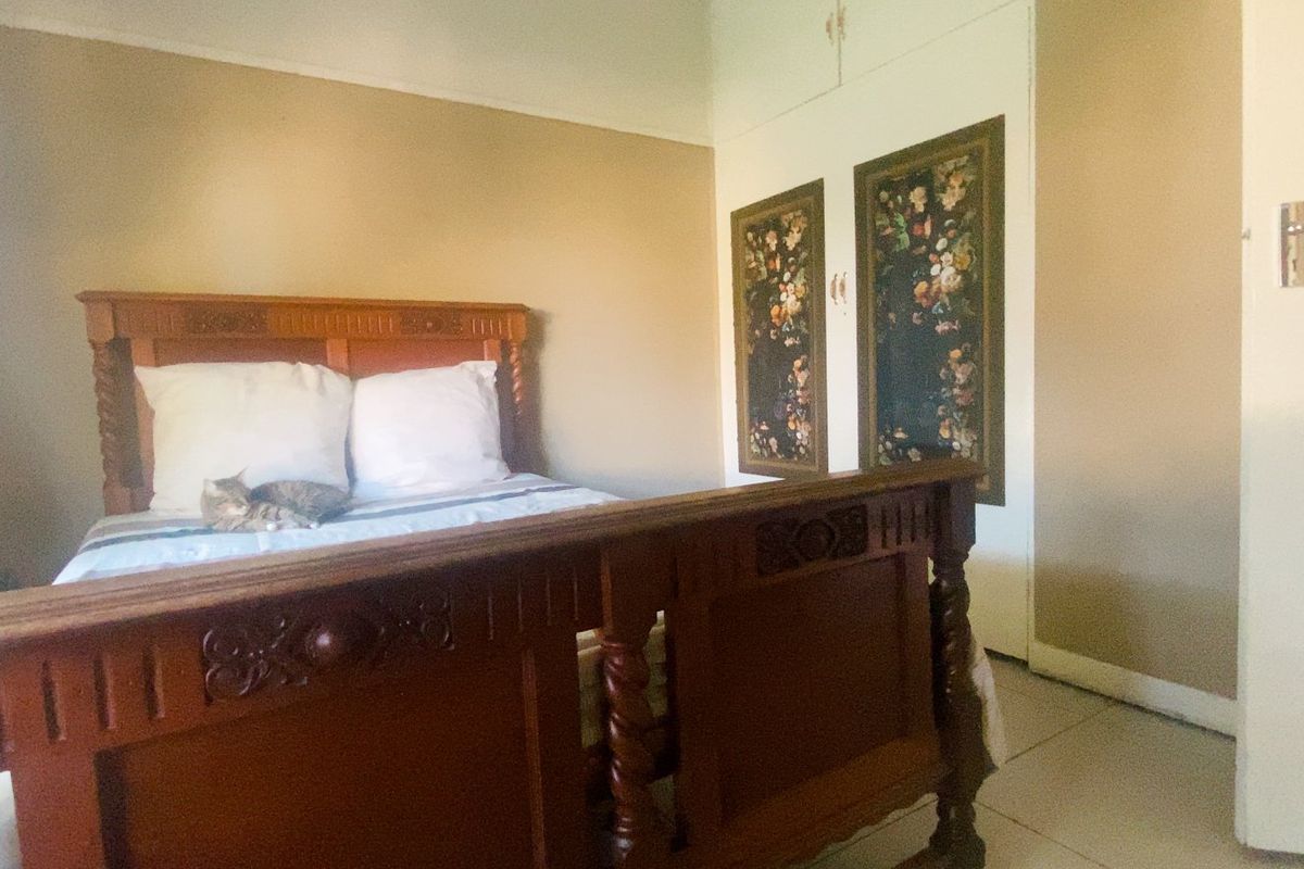 A bedroom featuring built-in cupboards and tiled flooring, offering a functional space with neutral wall tones.