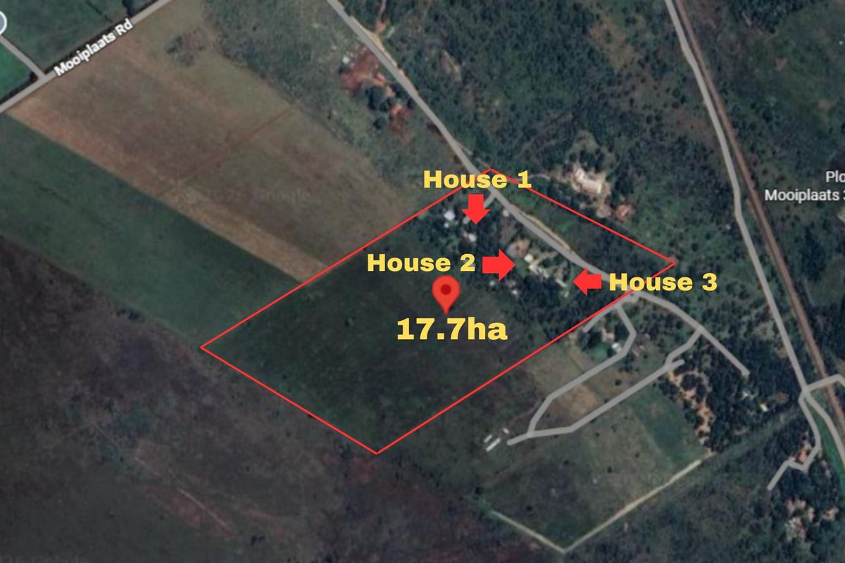 Aerial view of a 17.7-hectare farm property featuring three distinct residential dwellings and surrounding land.