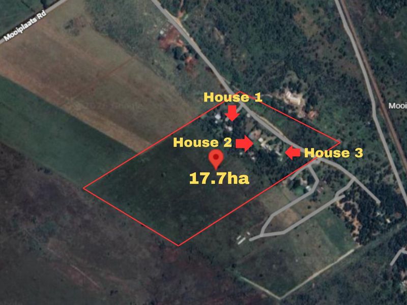 Aerial view of a 17.7-hectare farm property featuring three distinct residential dwellings and surrounding land.