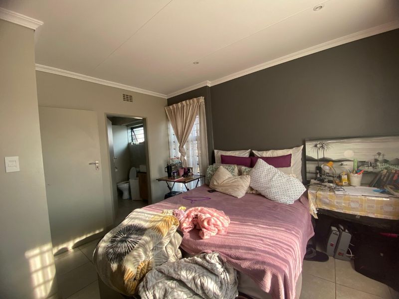A bedroom featuring tiled flooring, recessed ceiling lighting, and direct access to an en-suite bathroom.