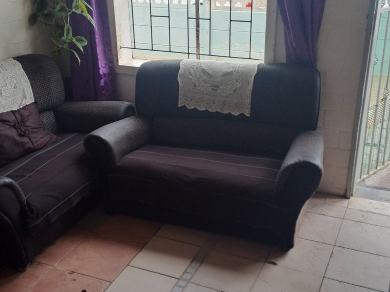 Living room area featuring tiled flooring with visible damage and security bars on the window.