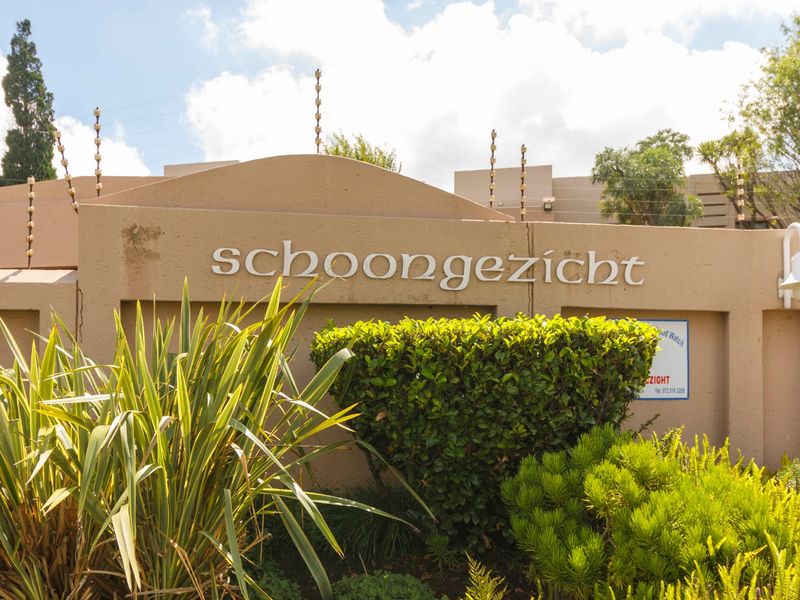 Exterior view of the Schoongezicht complex entrance featuring a perimeter wall with integrated electric fencing and signage.