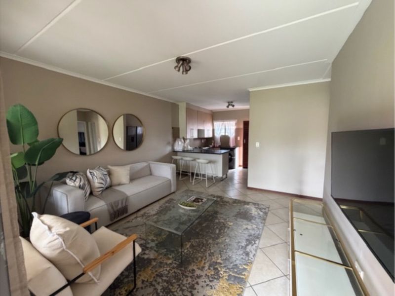 Open-plan living area featuring a kitchen with island and tiled flooring, creating a functional and connected space.