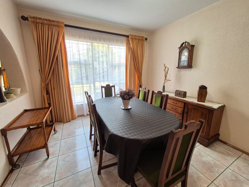 A dining room featuring tiled flooring and a large sliding glass door that provides natural light.