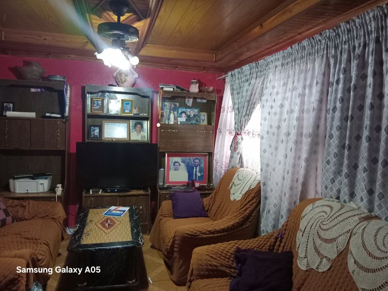 A living room featuring a timber-paneled ceiling and a central ceiling fan, providing a traditional aesthetic.