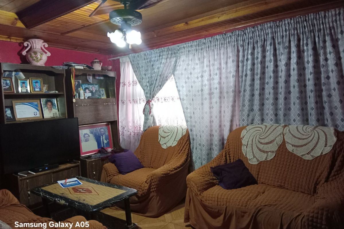 A living room featuring a timber ceiling with a central ceiling fan and tiled flooring.