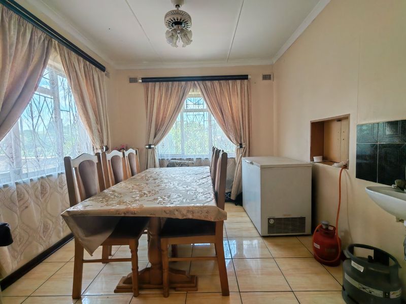 Dining room featuring tiled flooring, a ceiling fan, and a wall-mounted basin with an integrated wall niche.