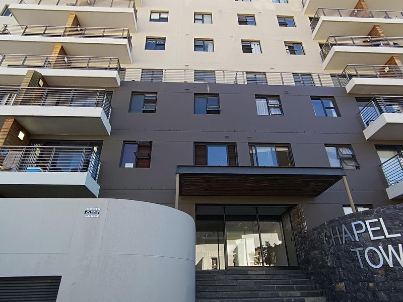 Front elevation of Chapel Towers apartment building featuring modern balconies, stone cladding, and a prominent glass entrance.