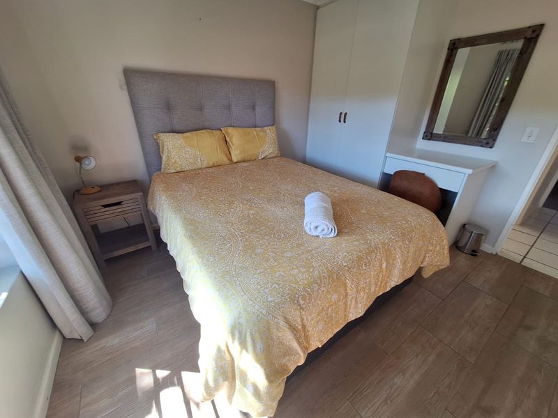 A well-maintained bedroom featuring tiled flooring and a built-in wardrobe, offering a functional and comfortable living space.