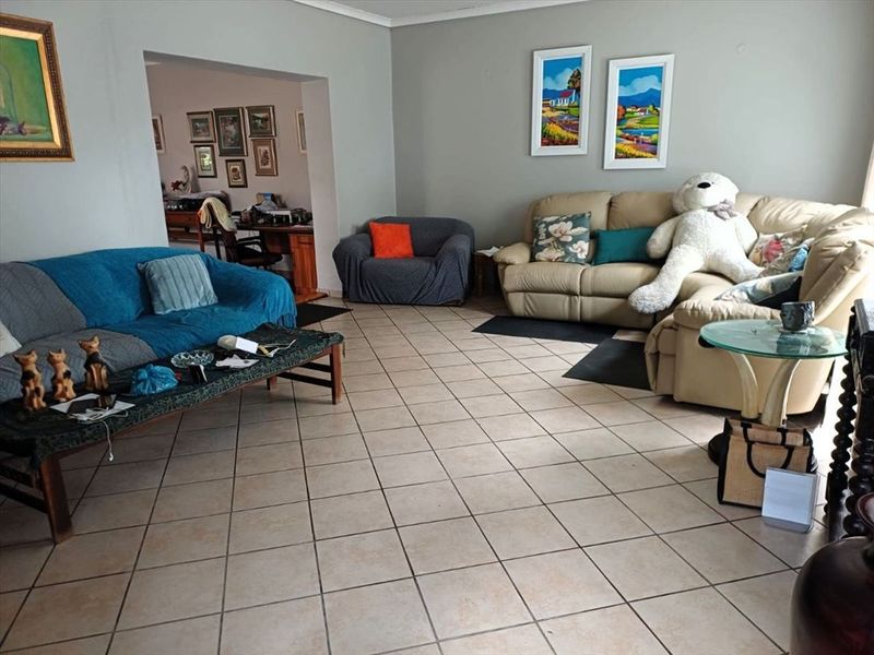 Spacious living room featuring neutral wall tones and ceramic floor tiles, offering a comfortable and functional layout with an adjacent secondary living area.