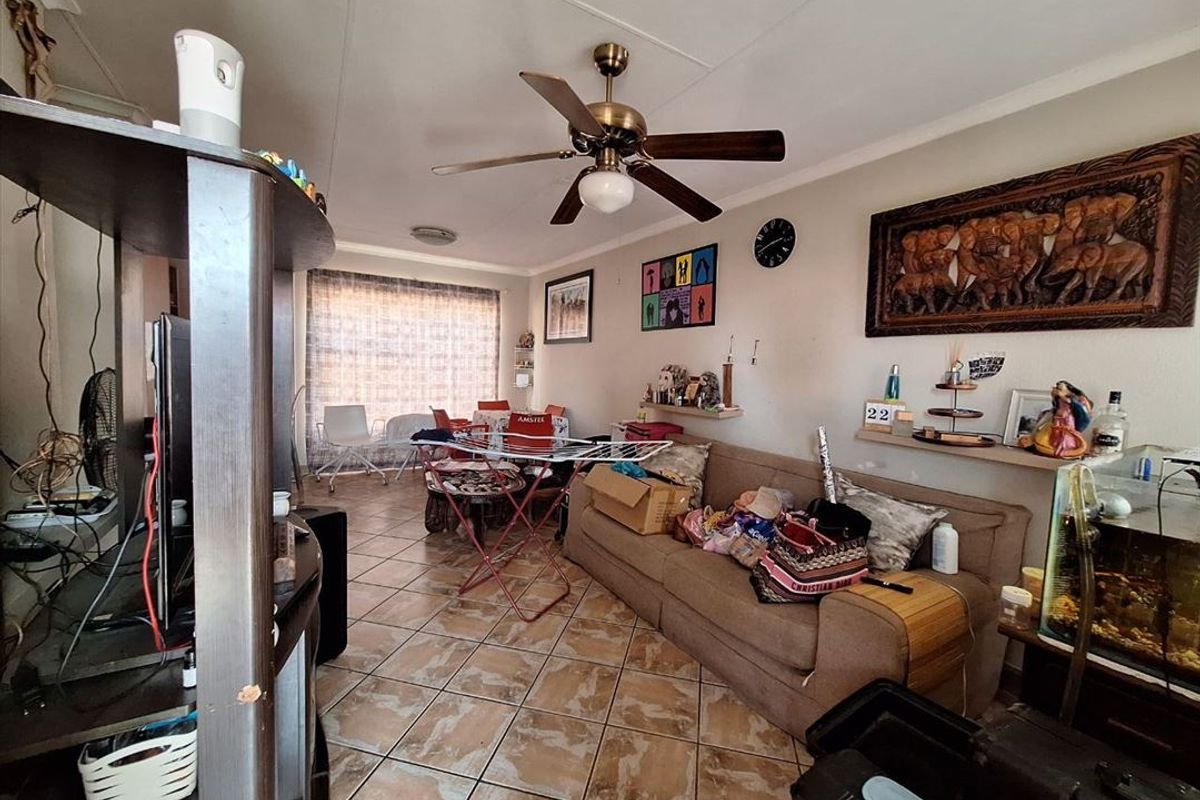 Open plan living and dining area featuring tiled flooring and a ceiling fan, providing a functional space for daily living.