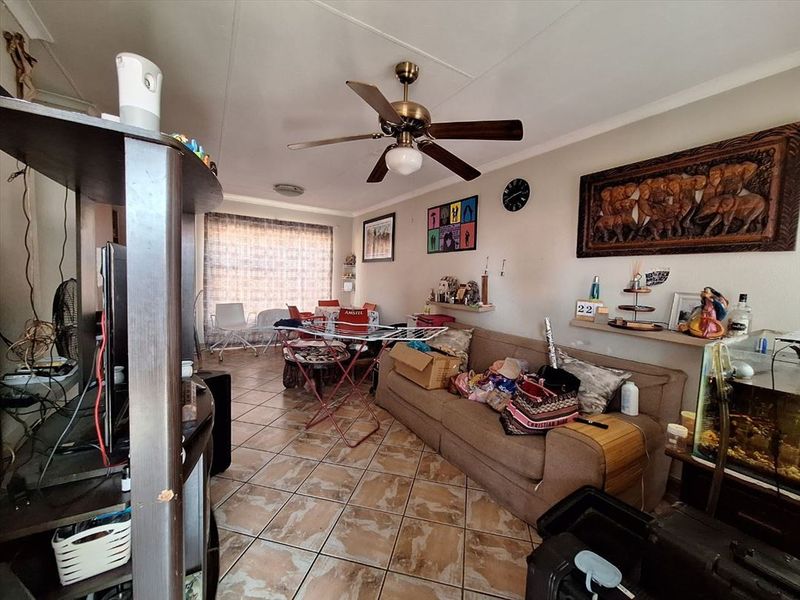 Open plan living and dining area featuring tiled flooring and a ceiling fan, providing a functional space for daily living.