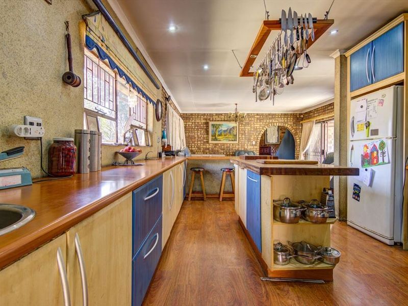 A functional kitchen featuring laminate countertops, a central island, and exposed brick accents, offering a rustic aesthetic with ample storage and workspace.