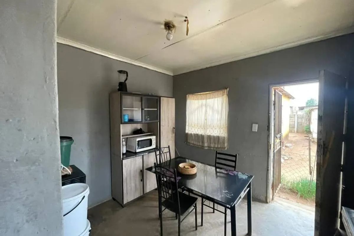 A small dining area featuring a simple layout with direct access to the exterior, requiring cosmetic updates to improve the overall finish and condition.