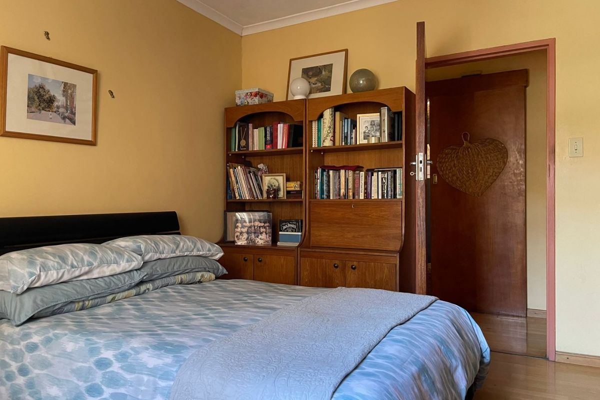 A bedroom featuring laminate flooring and coving, currently presented with a dated color scheme and requiring minor cosmetic updates to wall finishes.