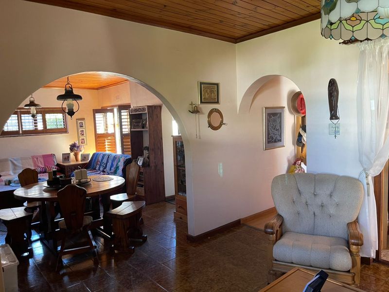 Open plan living and dining area featuring arched architectural transitions, timber ceiling paneling, and tiled flooring throughout.