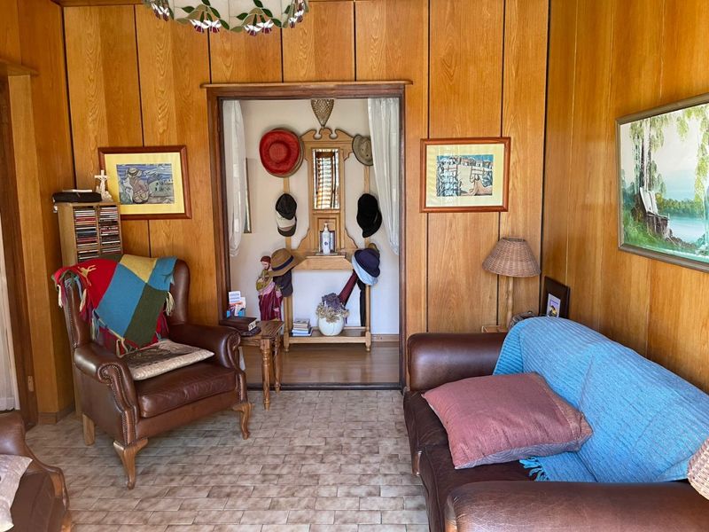 A living room featuring classic wood-paneled walls and tiled flooring, providing a traditional aesthetic with a cozy atmosphere.