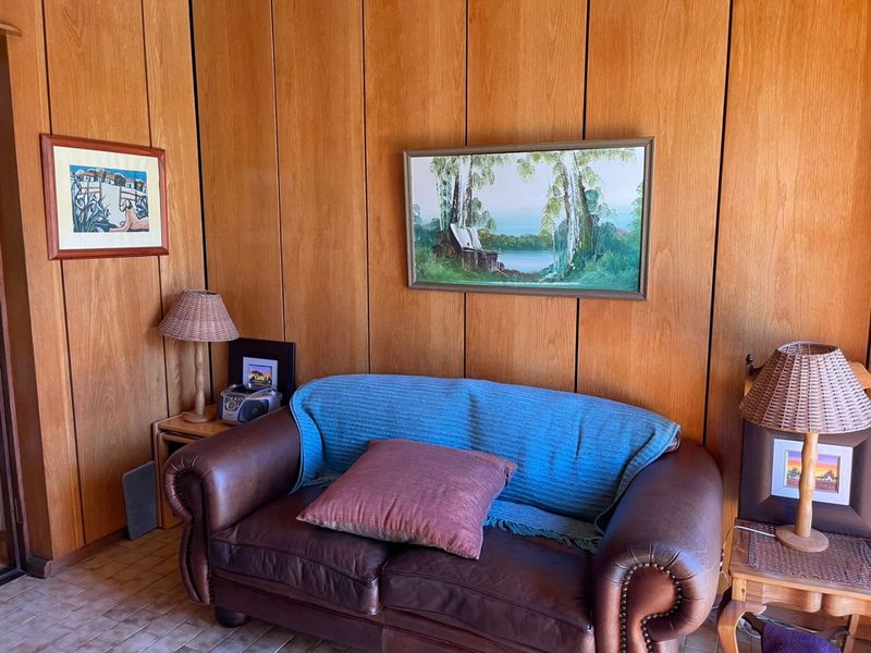 A living room area featuring classic timber wall paneling and tiled flooring, providing a warm and traditional aesthetic.