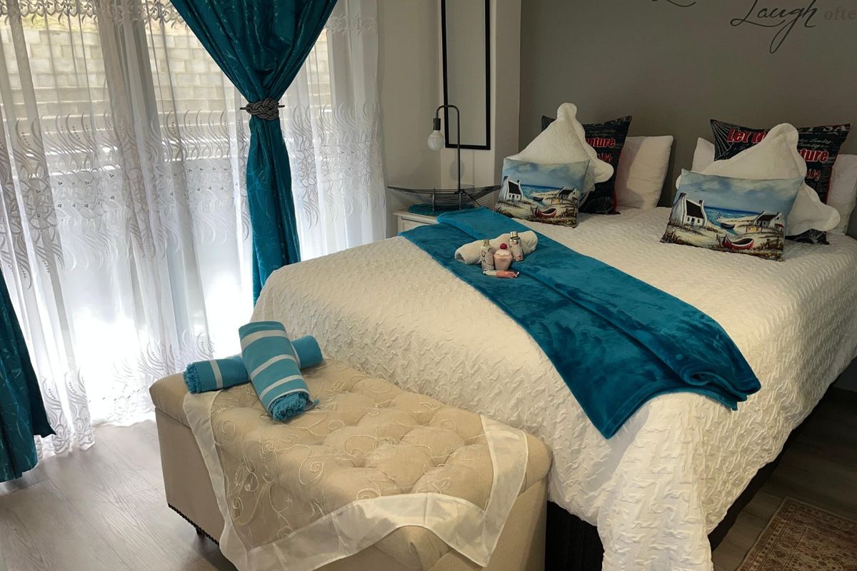 A well-maintained bedroom featuring laminate flooring and a large sliding glass door providing natural light.