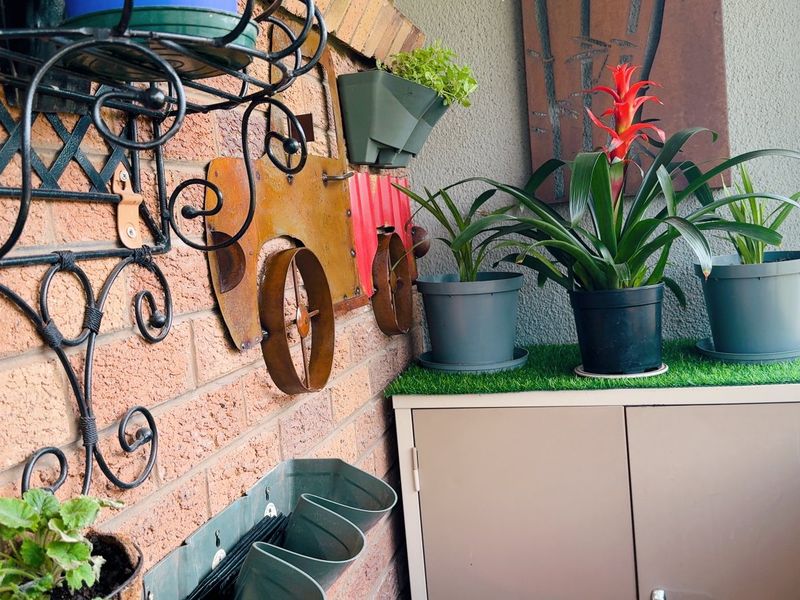 A covered balcony area featuring an exposed brick wall and large sliding glass windows, providing a bright and functional outdoor space.