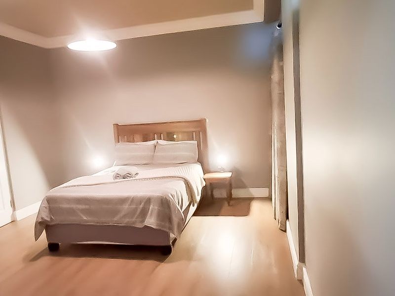 A well-maintained bedroom featuring neutral wall tones, laminate flooring, and coved ceiling details, providing a clean and comfortable living space.