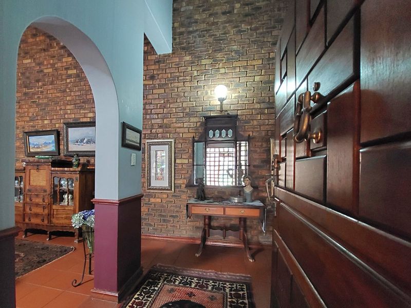 Welcoming entrance hall featuring exposed brick walls, an arched architectural detail, and traditional tiled flooring, leading into the main living area.