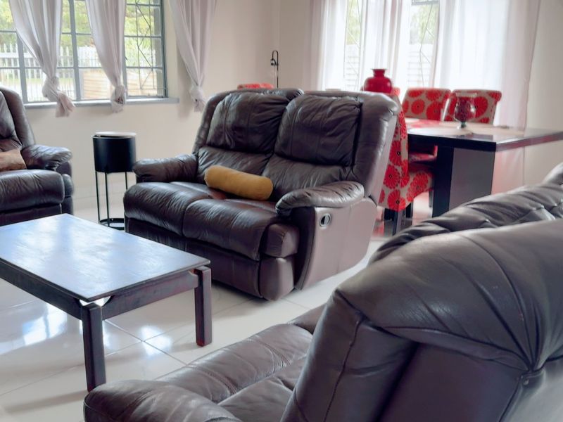 Spacious open-plan living and dining area featuring bright tiled flooring and large windows that provide ample natural light.