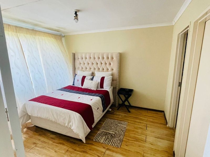 A bedroom featuring wood-look tile flooring and neutral wall tones, providing a functional space with potential for cosmetic updates to the ceiling and finishes.