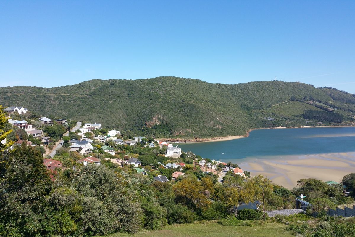A scenic elevated view overlooking the coastal landscape, estuary, and surrounding residential hillside.