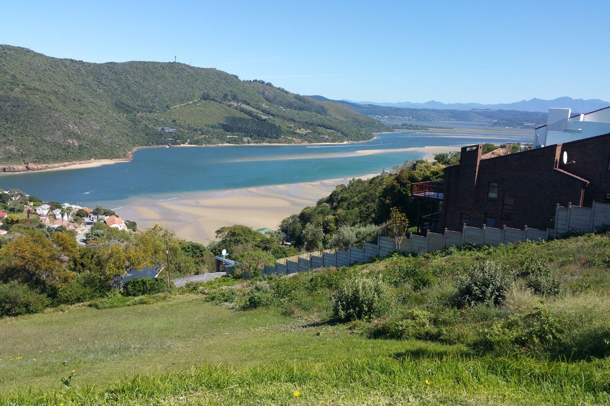 A scenic elevated view overlooking the estuary, sandy banks, and surrounding hills, showcasing the natural landscape and residential context of the vacant land.