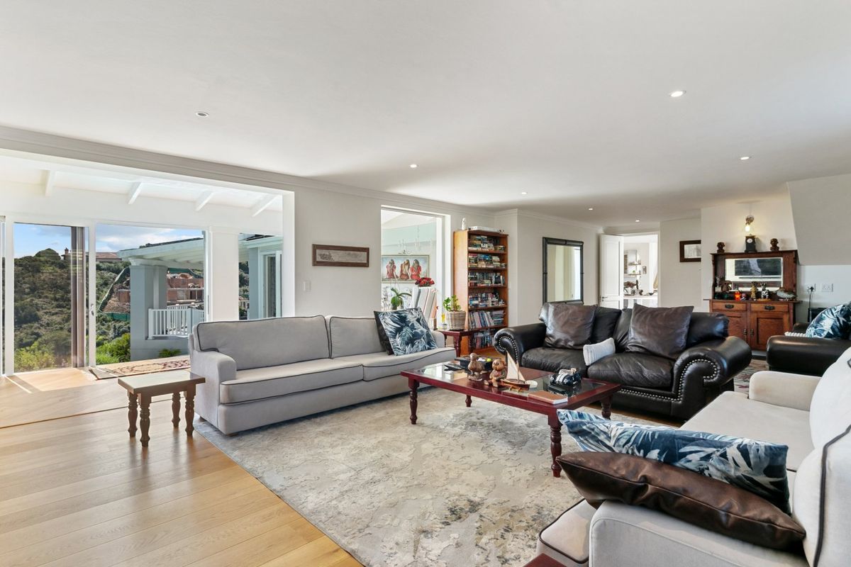 Spacious living room featuring hardwood flooring, recessed lighting, and large sliding glass doors opening to an outdoor patio area.