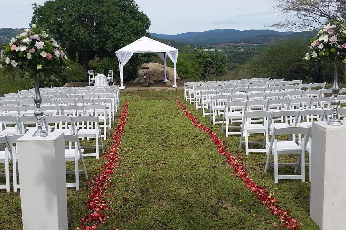 An outdoor garden setting featuring a manicured lawn, a gazebo, and scenic landscape views, suitable for events and ceremonies.