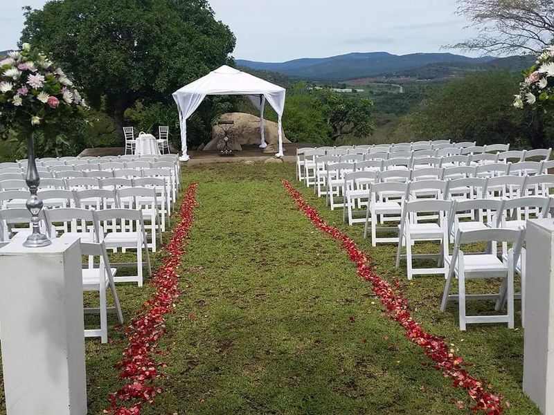 An outdoor garden setting featuring a manicured lawn, a gazebo, and scenic landscape views, suitable for events and ceremonies.