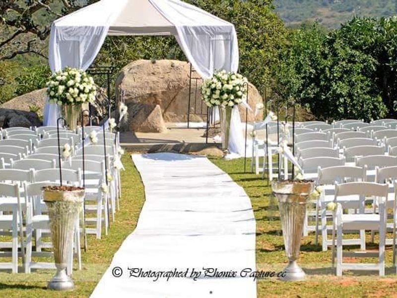 A scenic outdoor garden area featuring natural rock formations, suitable for events and gatherings within the farm property.
