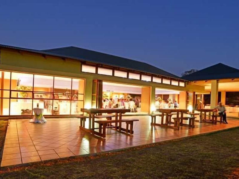 Spacious covered patio featuring tiled flooring and large glass sliding doors, providing seamless indoor-outdoor flow for evening entertainment.